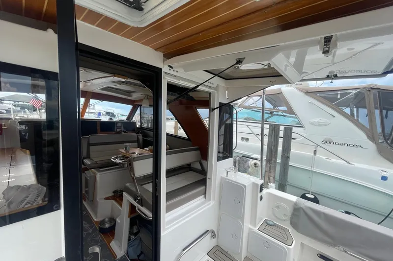 Slide: The Image of 2022 Cutwater C-30 Sedan interior view with seating and docked boats in background. - 28