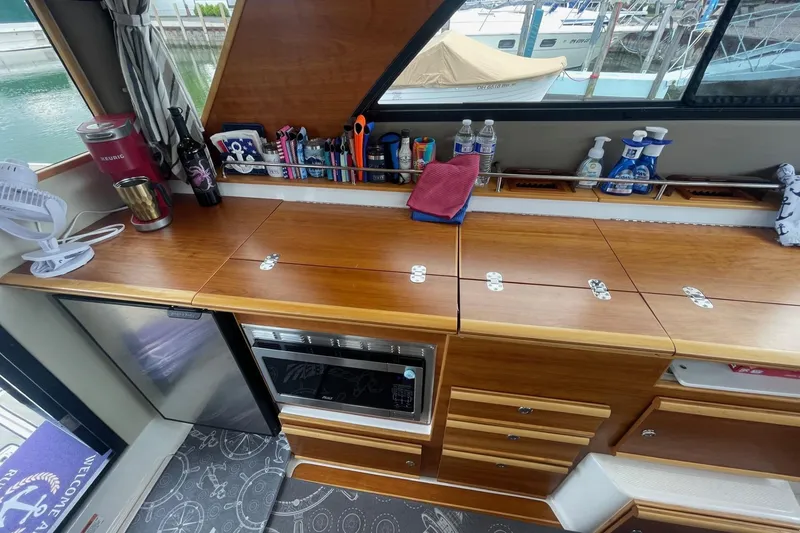 Slide: The Image of 2022 Cutwater C-30 Sedan interior with wooden cabinetry, appliances, and organized storage. - 33