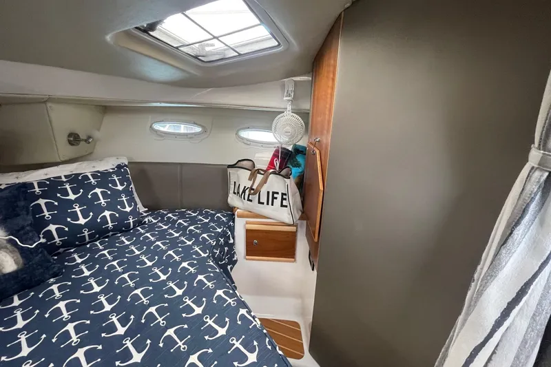 Slide: The Image of 2022 Cutwater C-30 Sedan cabin interior with nautical-themed bedding and "Lake Life" bag. - 41