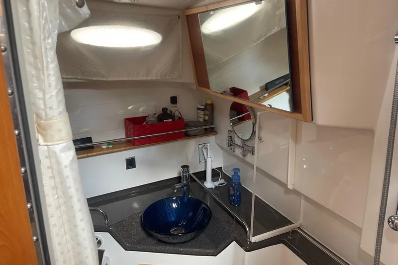 Slide: The Image of 2022 Cutwater C-30 Sedan bathroom with modern sink, mirror, and storage shelves. - 44