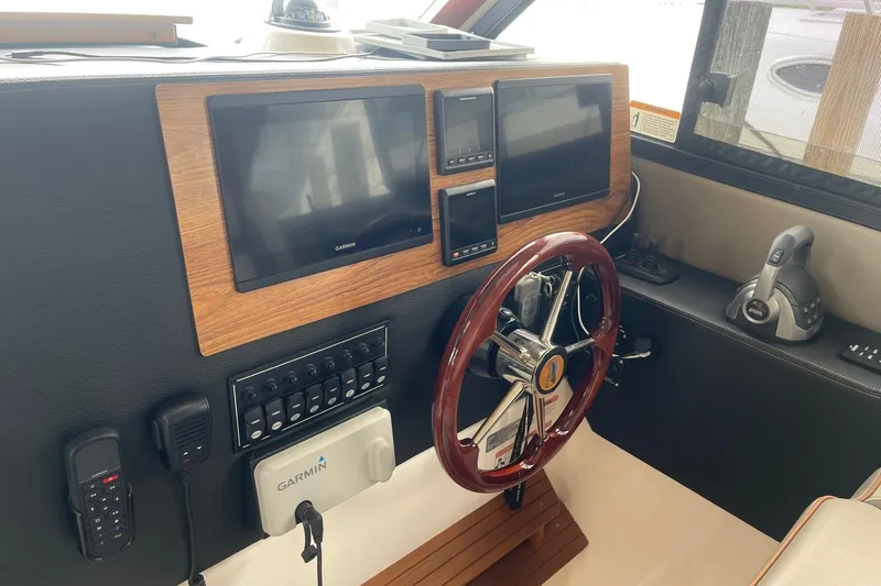 Slide: The Image of 2022 Cutwater C-30 Sedan helm with Garmin displays and wood-accented steering wheel. - 51