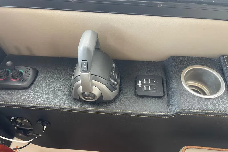 Slide: The Image of 2022 Cutwater C-30 Sedan boat controls with joystick, throttle, and cup holder. - 53