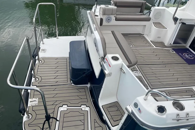 Slide: The Image of 2022 Cutwater C-30 Sedan boat deck with seating and railing, docked on calm water. - 7