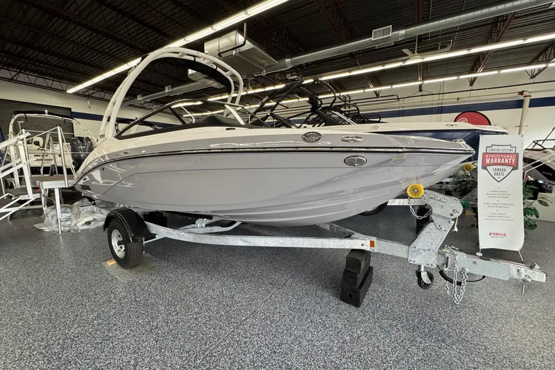 The Image of 2026 Yamaha Boats 195S displayed indoors on a trailer, featuring a sleek design. - 0