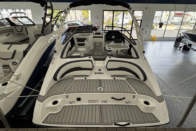 Slide: The Image of 2026 Yamaha Boats 195S interior view in showroom, featuring sleek seating and modern design. - 4