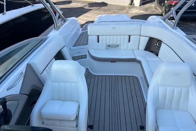 Slide: The Image of 2006 Cobalt 272 boat docked in a covered marina with scenic lake view. - 12