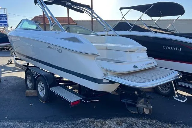 Slide: The Image of 2006 Cobalt 272 boat on trailer, parked outdoors near other boats. - 19