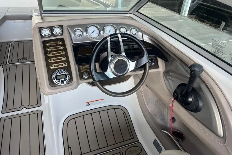 Slide: The Image of 2006 Cobalt 272 boat dashboard with steering wheel and control panel. - 2