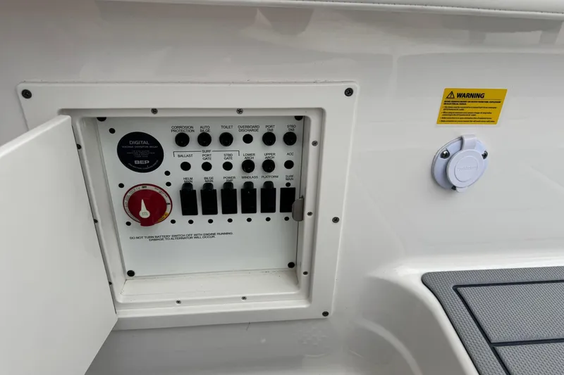 Slide: The Image of Control panel of 2026 Chaparral 8 SSX boat with switches and warning label. - 19