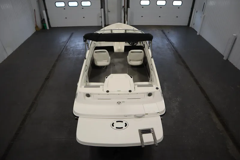 Slide: The Image of 2013 Bayliner 175 Bowrider boat in a garage, rear view, white interior. - 10