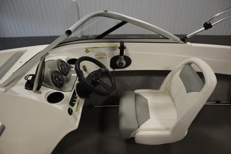 Slide: The Image of 2013 Bayliner 175 Bowrider cockpit with steering wheel, gauges, and white seating. - 14