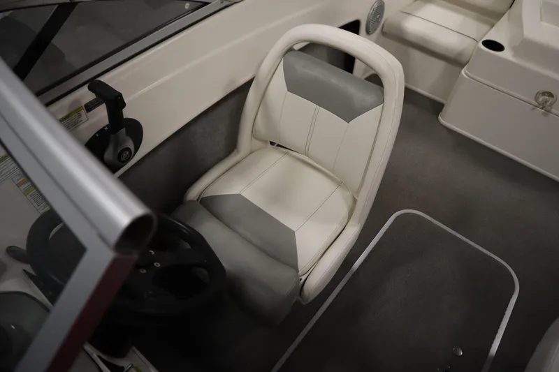 Slide: The Image of 2013 Bayliner 175 Bowrider interior with steering wheel and cushioned seat. - 22