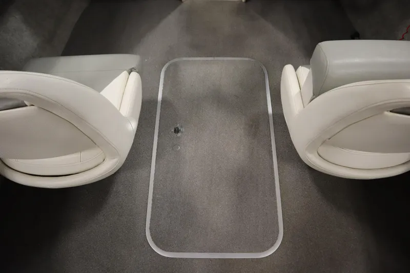 Slide: The Image of 2013 Bayliner 175 Bowrider interior with two white seats and carpeted floor. - 29