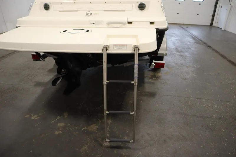 Slide: The Image of 2013 Bayliner 175 Bowrider rear view with ladder extended in a garage setting. - 36