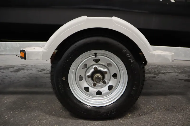 Slide: The Image of Trailer wheel of 2013 Bayliner 175 Bowrider, featuring a white fender and metal rim. - 43