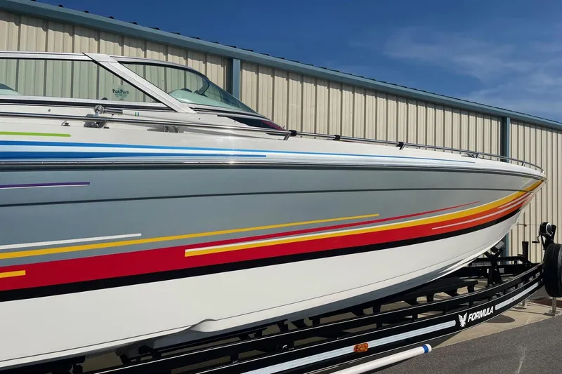 Slide: The Image of 2004 Formula 382 FASTech boat with colorful stripes on a trailer, parked outdoors. - 3
