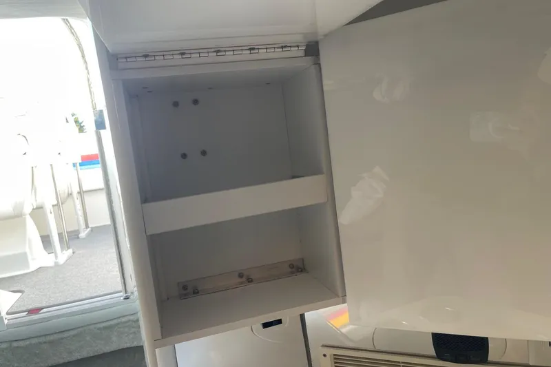 Slide: The Image of Open storage compartment inside a 2004 Formula 382 FASTech boat, showcasing interior shelving. - 53