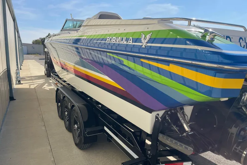 Slide: The Image of 2004 Formula 382 FASTech boat with vibrant stripes on a trailer. - 6