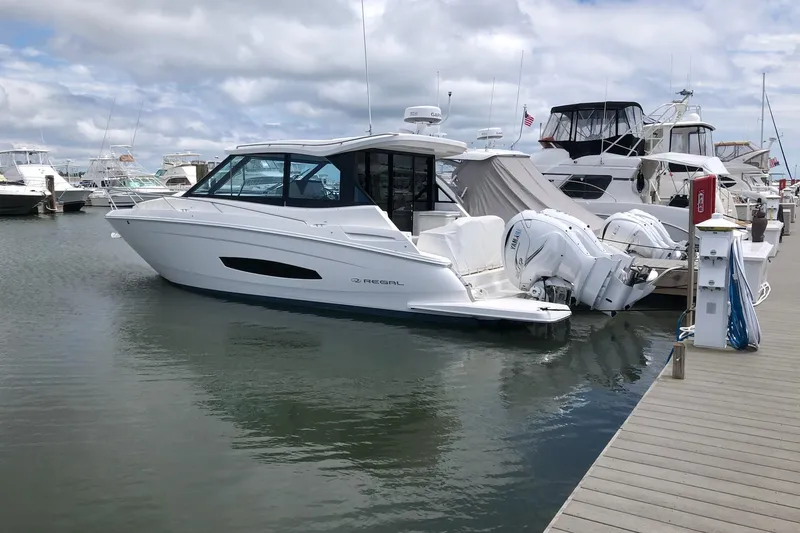 The Image of 2022 Regal 36 XO boat docked at marina with other vessels. - 0