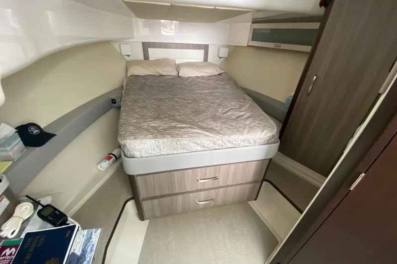 Slide: The Image of 2022 Regal 36 XO cabin interior with bed, storage, and navigation materials. - 19