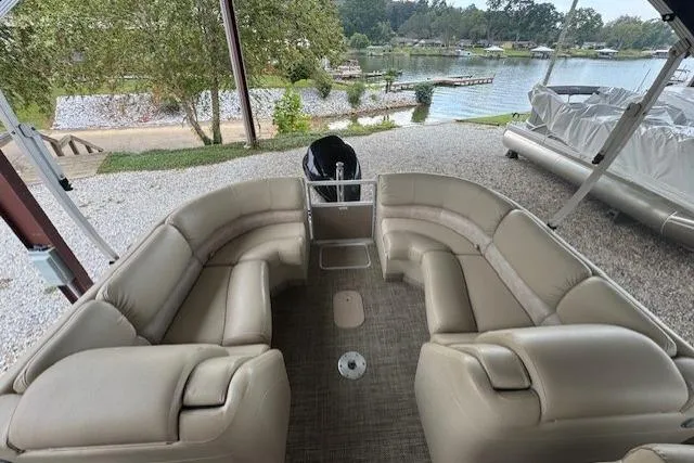Slide: The Image of 2015 Bennington 2350 RSR pontoon boat with spacious seating, docked by a scenic lake. - 12