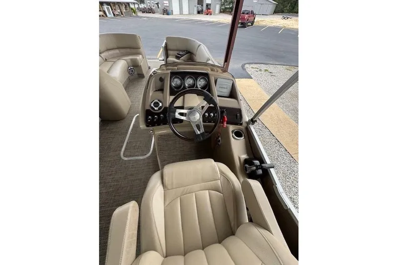 Slide: The Image of Interior view of 2015 Bennington 2350 RSR boat with beige seating and steering console. - 13