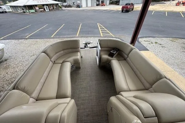 Slide: The Image of 2015 Bennington 2350 RSR pontoon boat with spacious seating, parked in a lot. - 14