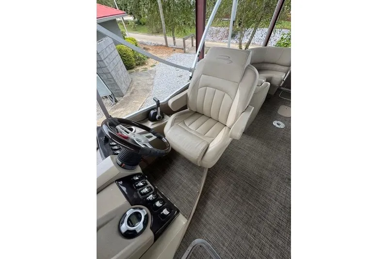 Slide: The Image of 2015 Bennington 2350 RSR boat interior with beige captain's chair and steering console. - 18