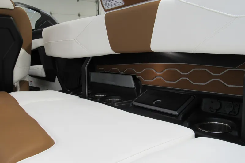 Slide: The Image of 2026 Malibu Wakesetter 23 LSV interior with white and brown seating, cup holders, and storage. - 7