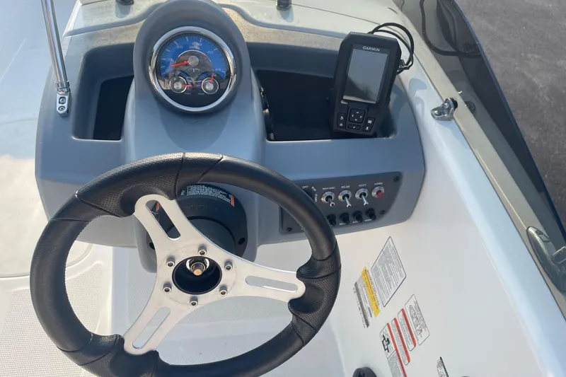 Slide: The Image of 2021 Tahoe T-16 boat dashboard with steering wheel and Garmin device. - 11