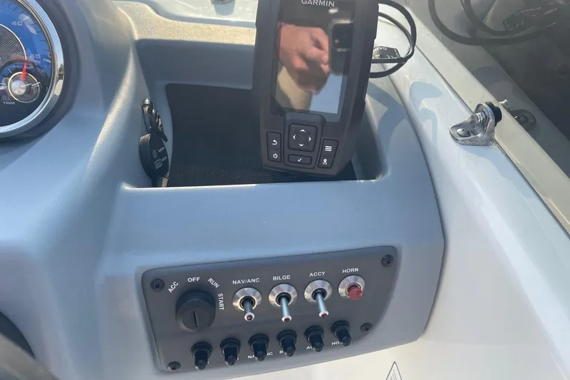 Slide: The Image of Control panel of 2021 Tahoe T-16 boat with Garmin device and switches. - 13