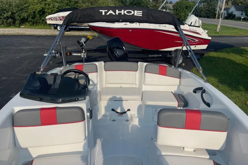 Slide: The Image of 2021 Tahoe T-16 boat interior with red and gray seating, parked on a trailer. - 16