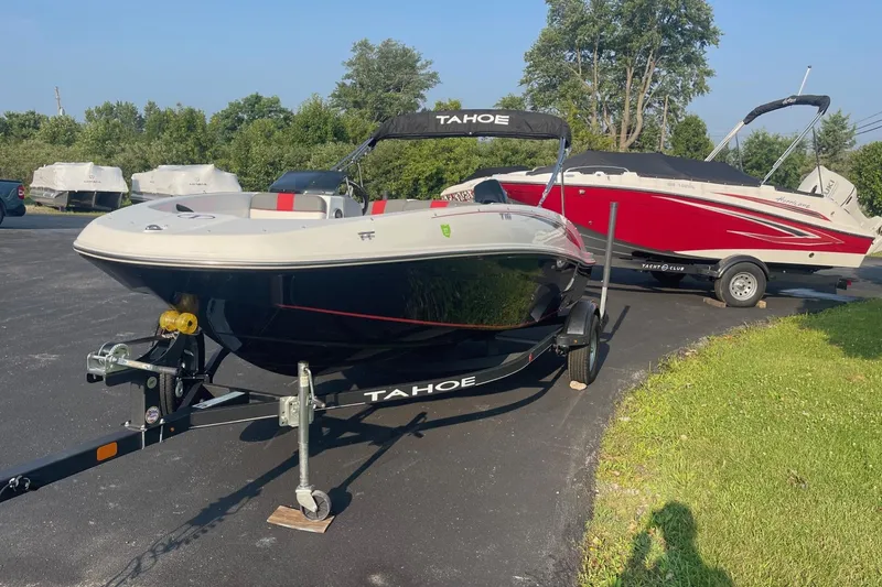 Slide: The Image of 2021 Tahoe T-16 boat on trailer, parked outdoors with another boat nearby. - 3