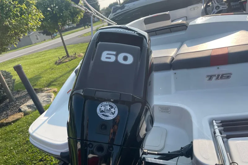 Slide: The Image of 2021 Tahoe T-16 boat with a 60 HP Mercury outboard motor, parked on grass. - 7