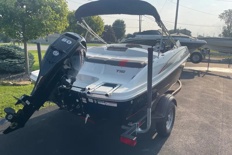 Slide: The Image of 2021 Tahoe T-16 boat with Mercury 60 engine on trailer, parked outdoors. - 8