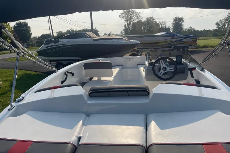 Slide: The Image of 2021 Tahoe T-16 boat interior with steering wheel and seating, parked outdoors. - 9