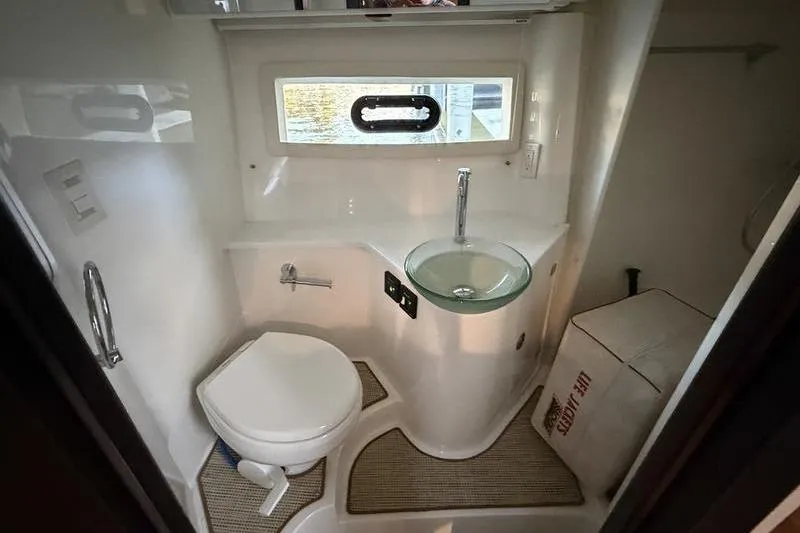Slide: The Image of 2015 Cobalt A40 boat bathroom with toilet, glass sink, and window. - 2