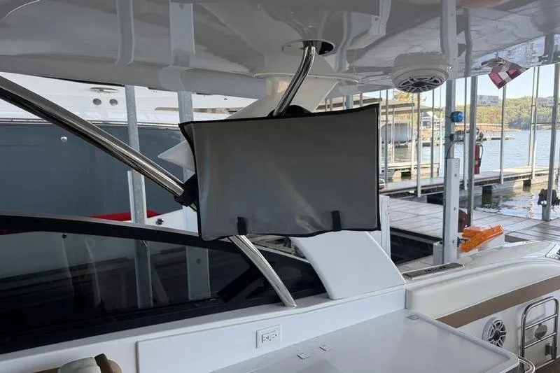 Slide: The Image of 2015 Cobalt A40 boat interior with mounted screen, docked at marina. - 9