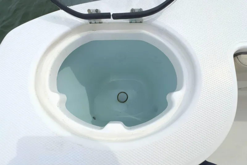 Slide: The Image of 2019 Robalo R272 Center Console livewell with open lid, filled with water. - 11