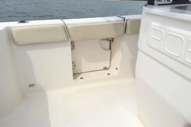 Slide: The Image of 2019 Robalo R272 Center Console boat interior with cushioned seating and storage compartment. - 14