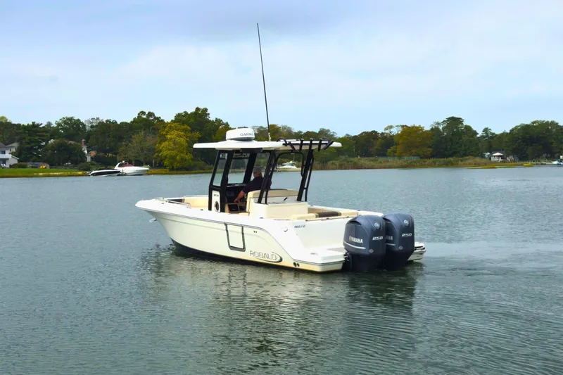 Slide: The Image of 2019 Robalo R272 Center Console boat on calm water with twin Yamaha engines. - 2