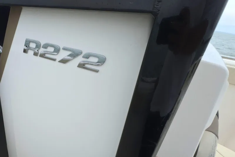 Slide: The Image of 2019 Robalo R272 Center Console boat emblem on white surface. - 23