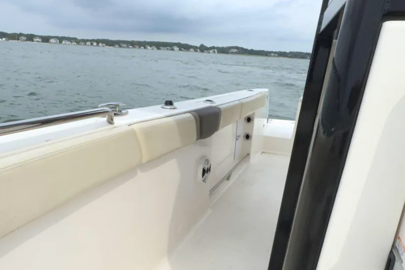 Slide: The Image of 2019 Robalo R272 Center Console boat on water, showcasing interior seating and railing. - 24