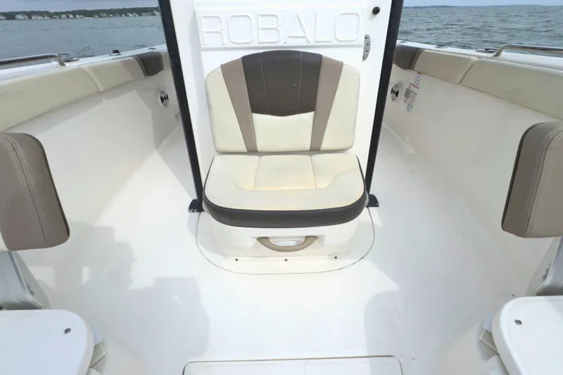 Slide: The Image of 2019 Robalo R272 Center Console boat interior with cushioned seating and ocean view. - 25