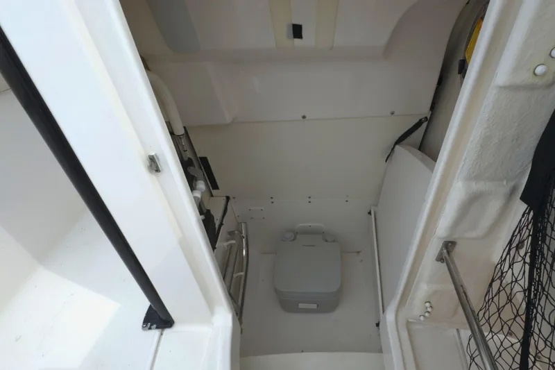 Slide: The Image of 2019 Robalo R272 Center Console interior with compact marine toilet. - 26