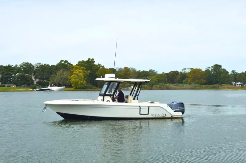 Slide: The Image of 2019 Robalo R272 Center Console boat cruising on a calm lake. - 3
