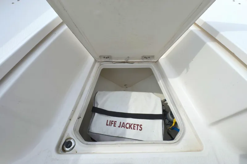 Slide: The Image of 2019 Robalo R272 Center Console storage compartment with life jackets. - 33