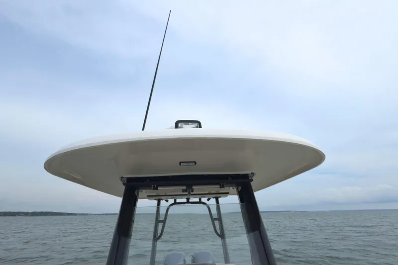 Slide: The Image of 2019 Robalo R272 Center Console boat's T-top against a cloudy sky. - 36