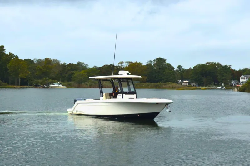Slide: The Image of 2019 Robalo R272 Center Console boat cruising on a calm lake. - 5