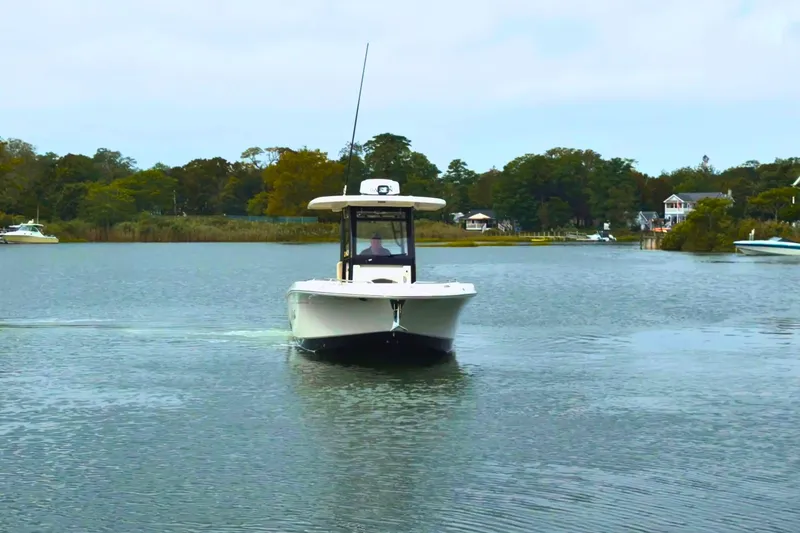 Slide: The Image of 2019 Robalo R272 Center Console boat cruising on a calm lake. - 6
